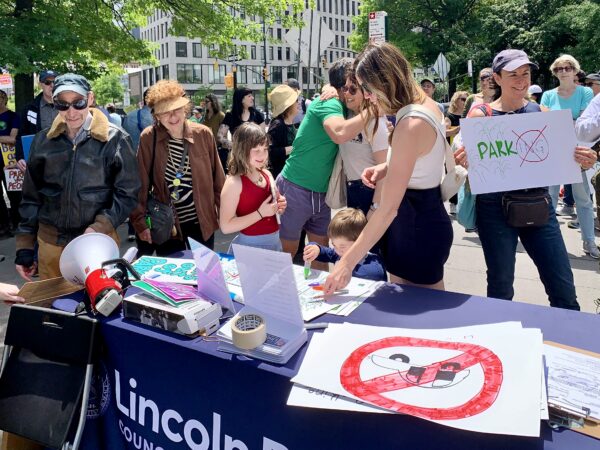 Attendees at Sunday’s Columbus Park rally make signs and sign petitions. Photo: Mary Frost/Brooklyn Eagle