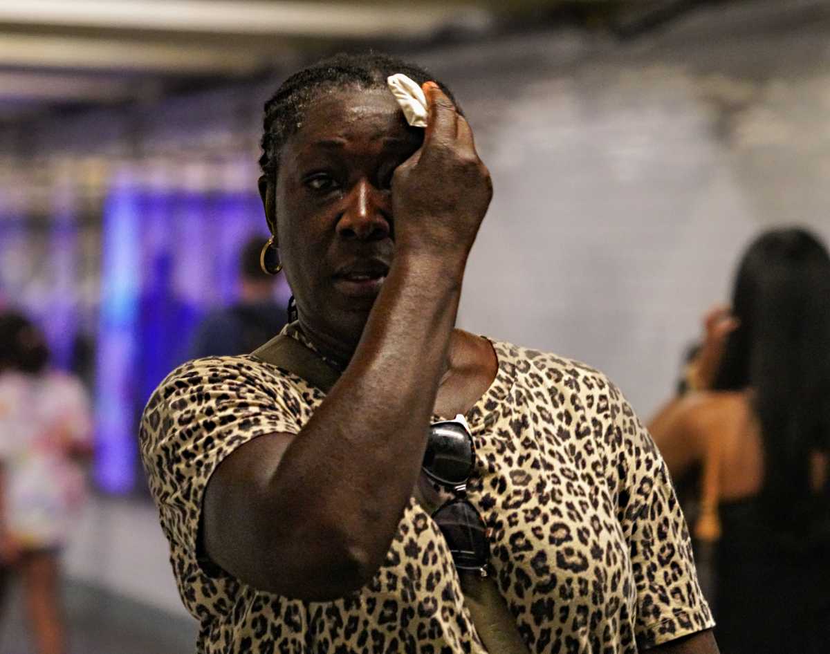 FILE - A woman wipes sweat from her brow while waiting for a subway train during a heat wave on July 16, 2024.