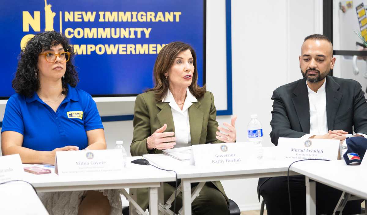 Gov. Kathy Hochul speaks at table with people about ICE and rumored immigration sting.