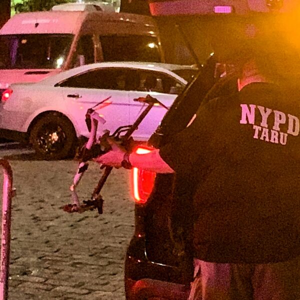 A member of NYPD’s Technical Assistance Response Unit packs a recovered piece of the drone into the back of an SUV on Water Street. Photo: Mary Frost/Brooklyn Eagle