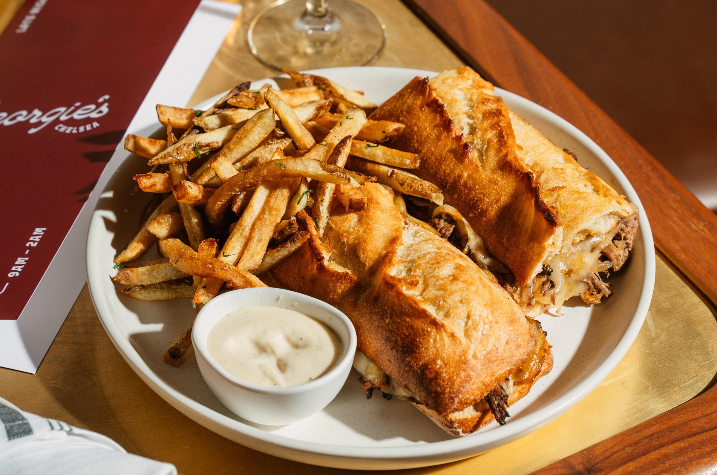 A plate of fries and a cut-in-half sandwich.