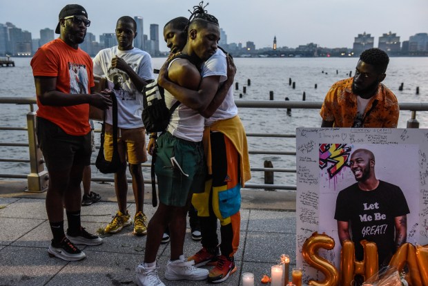 NEW YORK, NEW YORK - AUGUST 5: People hug next to a makeshift memorial for O'Shae Sibley on August 5, 2023 in New York City. O'Shae Sibley was stabbed to death at a gas station in Brooklyn on July 29th after being seen dancing in the parking lot. (Photo by Stephanie Keith/Getty Images)
