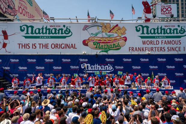 Participants compete for the men's title at Nathan's Annual Hot Dog Eating Contest on July 4, 2024 in New York City. (Photo by Adam Gray/Getty Images)