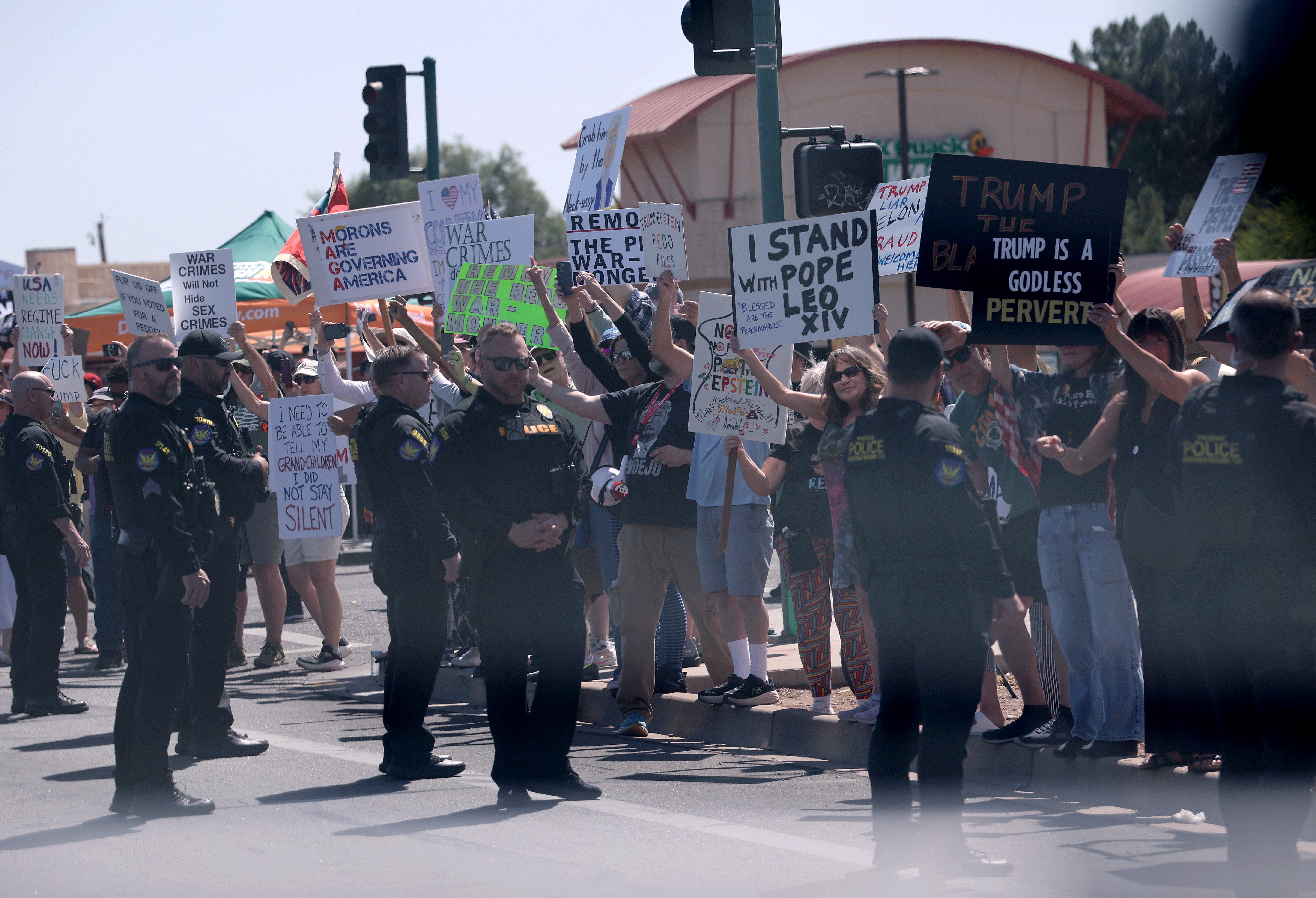 Protesters hold signs protesting the Trump administration in Phoenix, Arizona, in April. Arizona lawmakers are currently considering their own version of a 'civil terrorism' bill