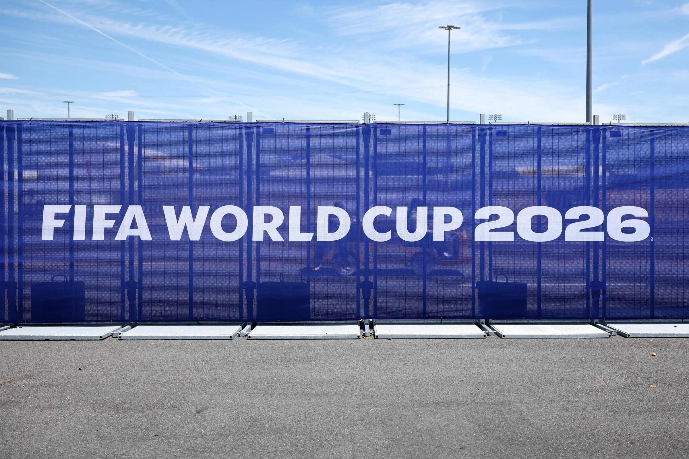 A screen fence outside with words reading “FIFA WORLD CUP 2026.”