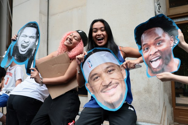 NEW YORK, NEW YORK - JUNE 18: Fans poses with posters of Jose Alvarado #5, Josh Hart #3 and Og Anunoby #8 of the New York Knicks ahead of the New York Knicks Championship ticker tape parade and victory rally celebrating winning the 2026 NBA Finals on June 18, 2026 in New York City. The New York Knicks defeated the San Antonio Spurs in five games to win their first NBA Championship in 53 years. (Photo by Michael M. Santiago/Getty Images)