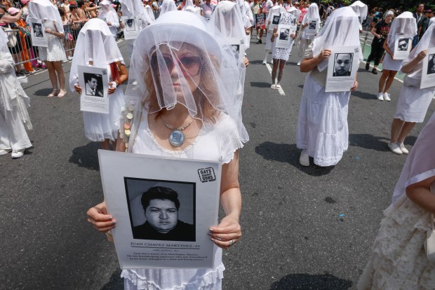 TOPSHOT - Activists from "Gays Against Guns" hold photographs of victims as they march for LGBTQ rights during the annual New York City Pride March in New York on June 28, 2026. (Photo by kena betancur / AFP via Getty Images)