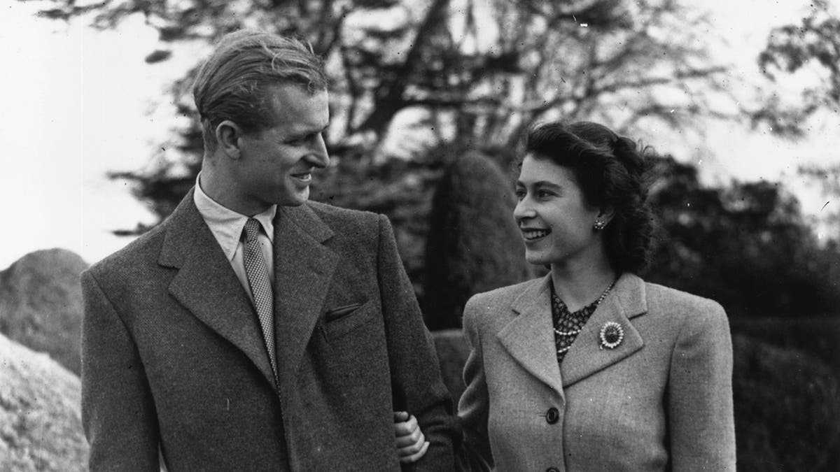 Princess Elizabeth and Prince Philip walking together outdoors during honeymoon
