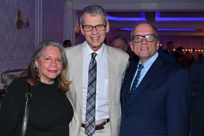 woman dressed in black and two men in suits