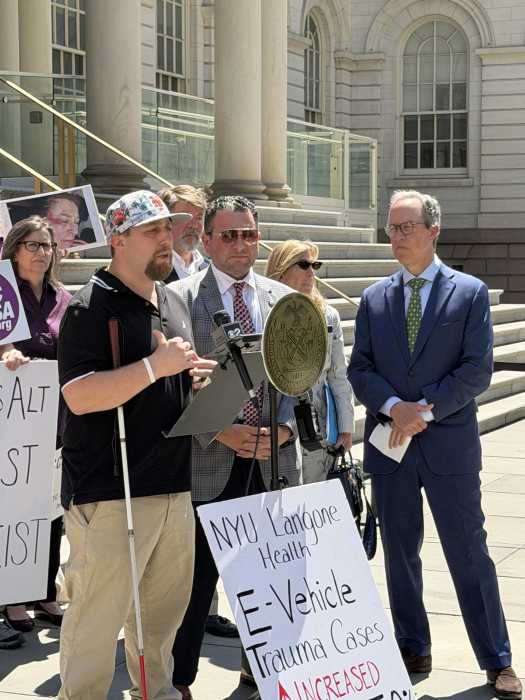 people talking at a podium outside a city building
