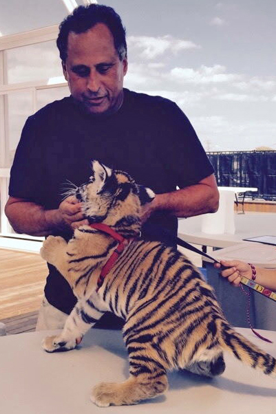 Larry Wallach interacts with a tiger cub. Wallach has long operated exotic animal attractions and held federal licenses to exhibit a variety of species. Credit: Courtesy of Bobby Zigman
