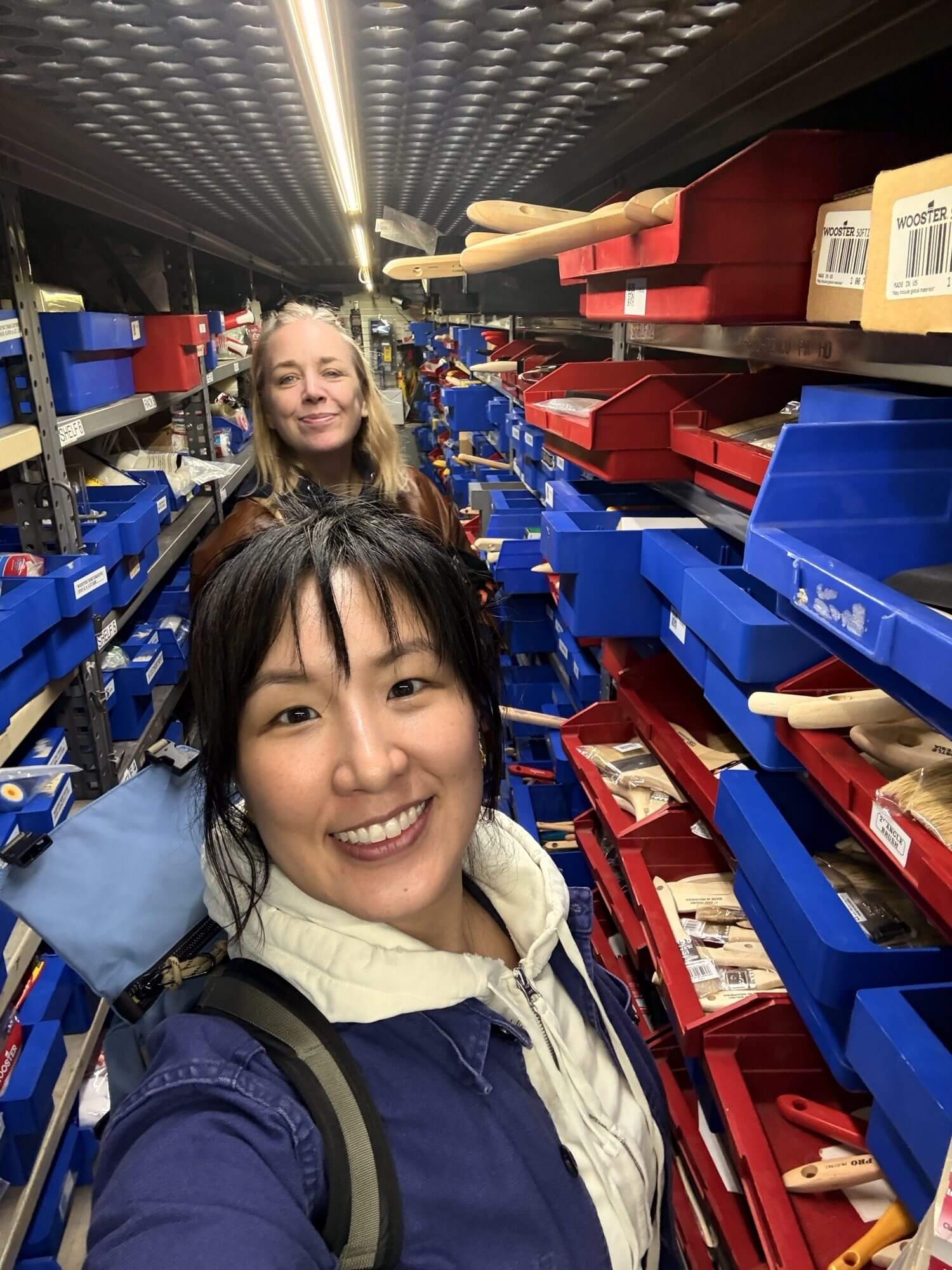 MTA assistant director of promotions Jen Chung stands in front of senior promotions manager Jen Carlson while posing for a selfie and picking out paint at Nuthouse Hardware.