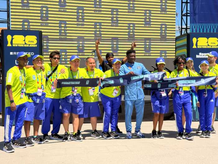 Director of Community Affairs at the Office of the Bronx Borough President David Coulibaly cuts the ribbon with volunteers, celebrating the opening of the official FIFA Bronx Fan Zone.