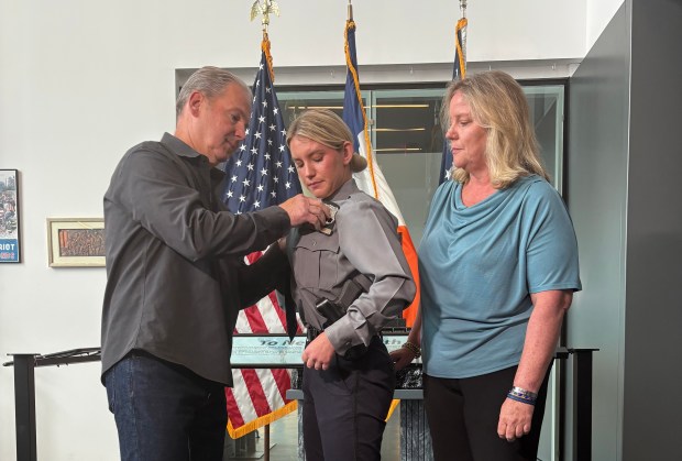 NYPD graduate Erica Tierney, center, gets her shield from her parents on Tuesday, June 23, 2026, in Queens, New York. (Roni Jacobson / New York Daily News)