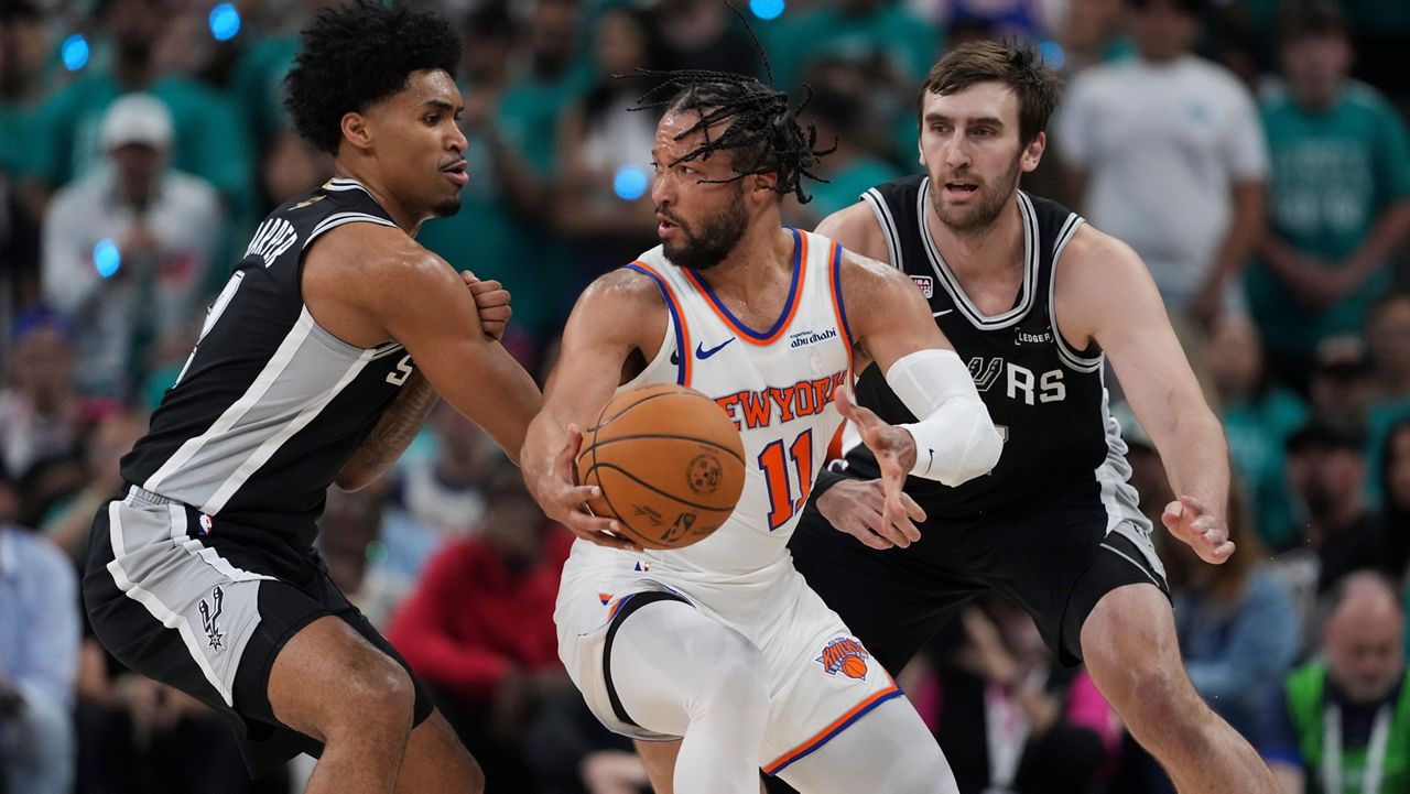 New York Knicks guard Jalen Brunson (11) spins as San Antonio Spurs guard Dylan Harper, left, defends during the first half of Game 1 of the NBA Finals basketball series on Wednesday, June 3, 2026, in San Antonio. (AP Photo/Eric Gay)