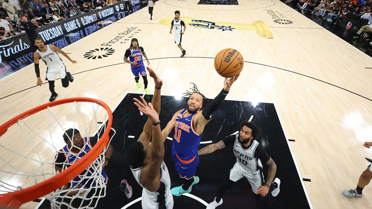 New York Knicks guard Jalen Brunson drives to the basket past San Antonio Spurs forward Julian Champagnie during the first half of Game 5 of the NBA Finals on Saturday, June 13, 2026, in San Antonio. (Geoff Burke/Pool Photo via AP)