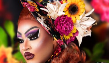 close-up side profile photo of a drag queen in heavy makeup wearing a hat decorated with artificial flowers