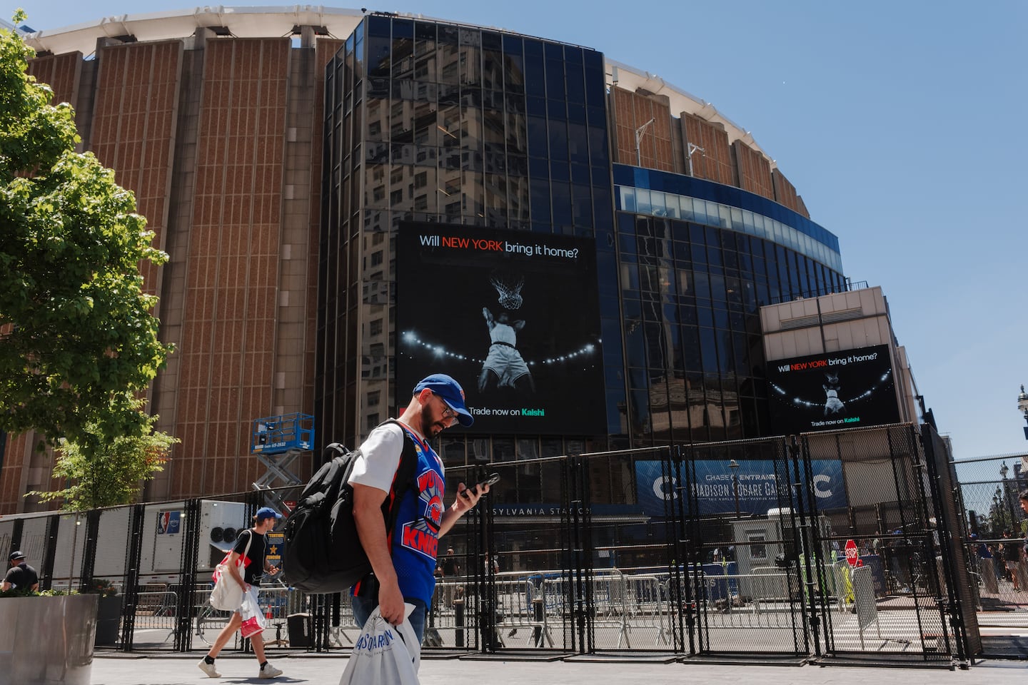 People walked near a security fence around Madison Square Garden ahead of Game 3 of the NBA Finals between New York Knicks and San Antonio Spurs on Monday. The New York City Police Department and Secret Service have cancelled a NBA Finals watch party near Madison Square Garden, with fans advised to arrive at least two hours before Monday's game due to heightened security for President Trump's attendance.