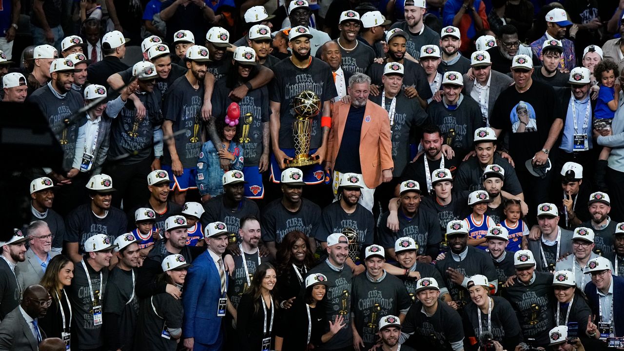 The New York Knicks pose with the Larry O'Brien Championship Trophy after defeating the San Antonio Spurs in Game 5 of the NBA Finals on Saturday, June 13, 2026, in San Antonio. (AP Photo/Ross D. Franklin)