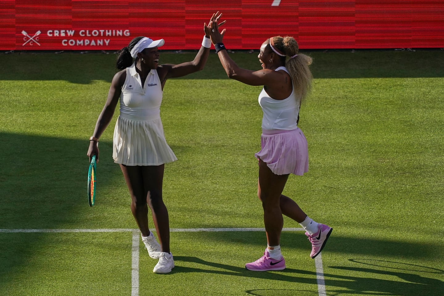 Serena Williams of the United States, right, celebrates with playing partner Victoria Mboko of Canada after winning a point against Nicole Melichar-Martinez of Canada and Erin Routliffe of New Zealand during their first round doubles match at the Queen's Club tennis championships in London, Tuesday, June 9, 2026.