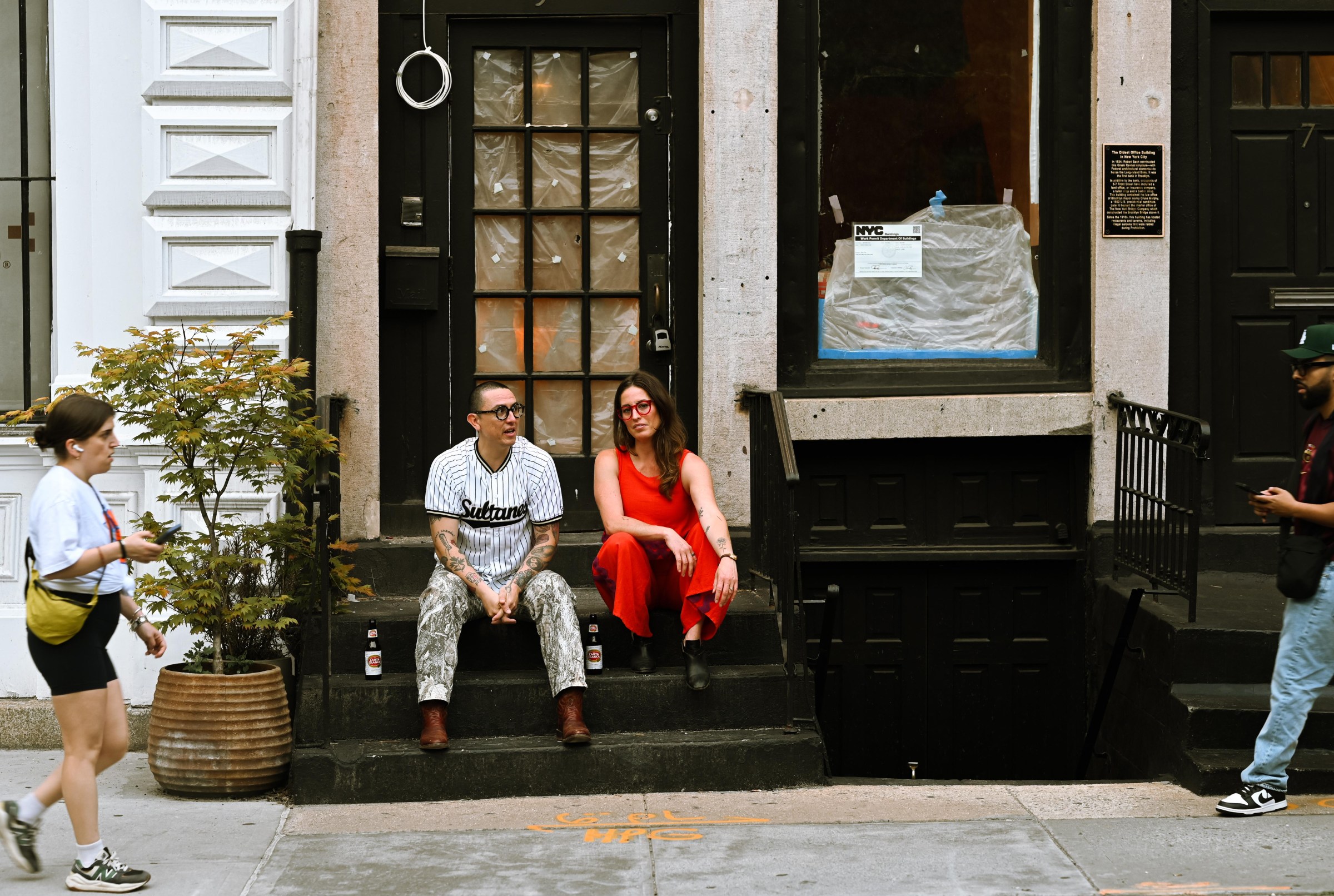 Two people sitting on a stoop.