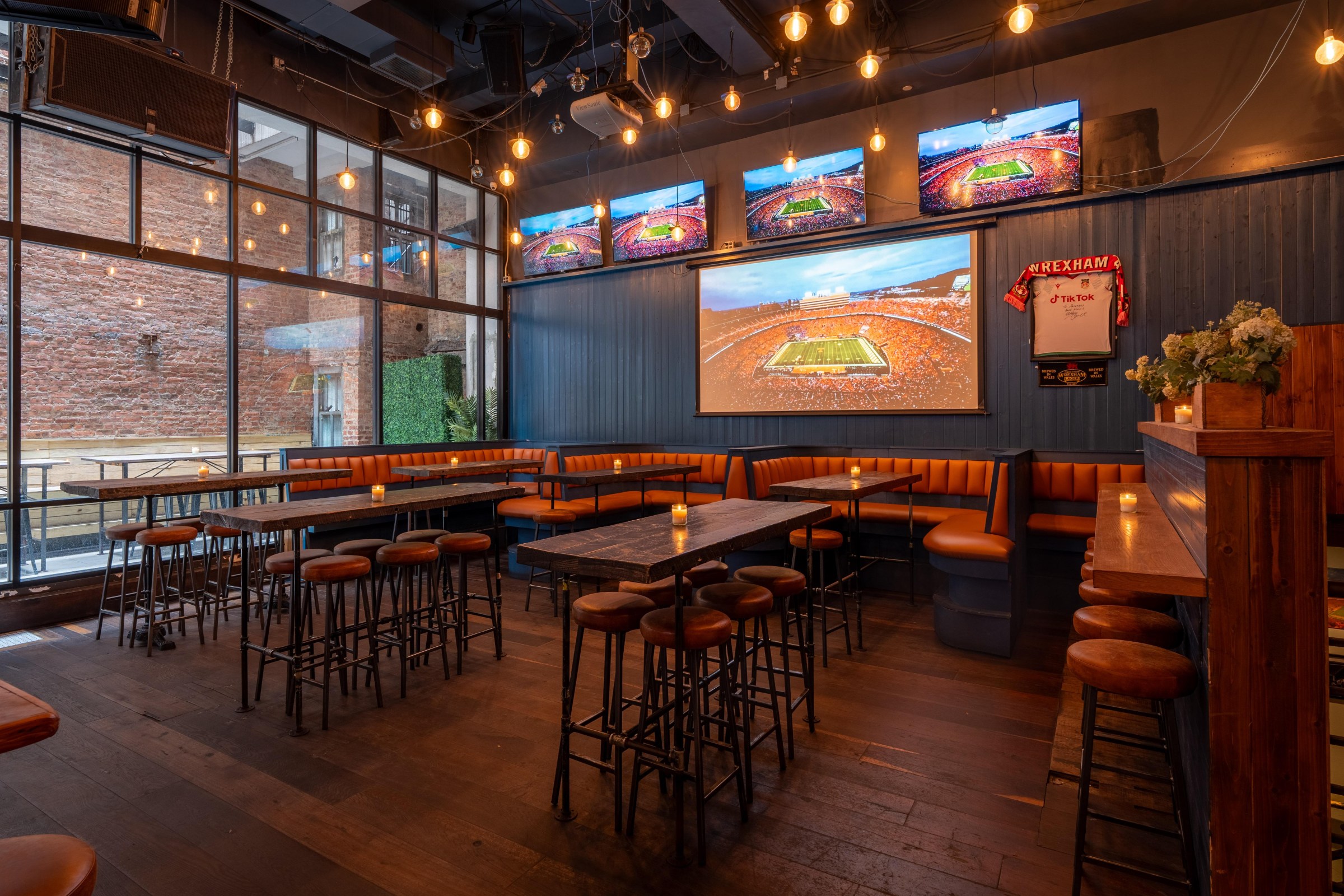 A sport bar with TV screens showing a stadium.