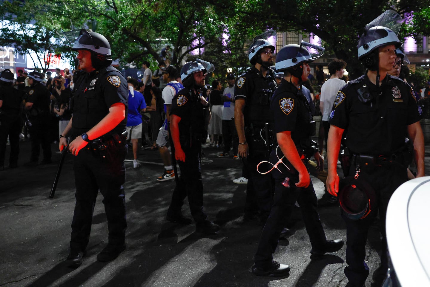 Police officers patrol as Knicks fans fill the street celebrating after the New York Knicks defeated the San Antonio Spurs in Game 5 of the NBA Finals to win the series, in New York, on June 14, 2026. The Knicks won the NBA Championship for the first time since 1973, for the third time in franchise history.