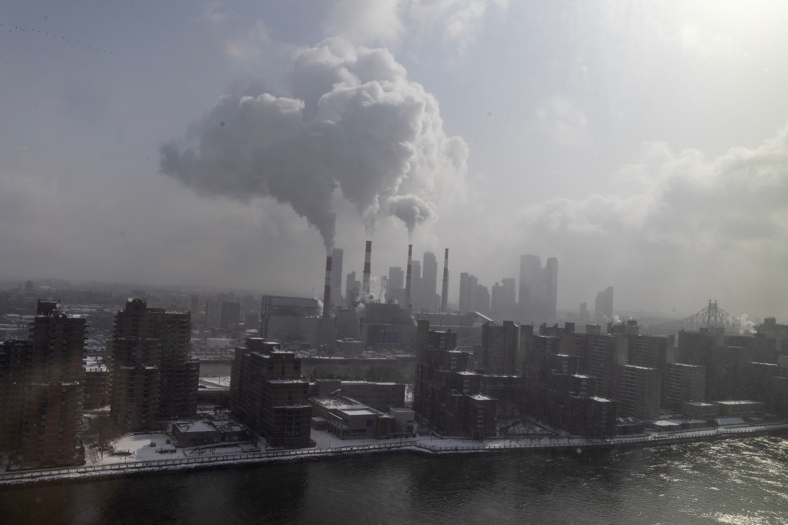 Steam rises from the smokestacks of the Ravenswood Generating Station, the largest power plant in New York City. The state has struggled to build out enough clean power to replace its natural gas power plants.
