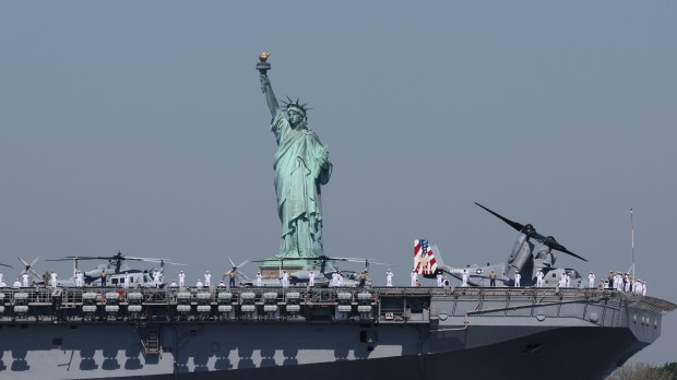Sailors from the USS Bataan (LHD 5) stand at attention while their ship sails past the Statue of Liberty early Wednesday, May 22, 2024, officially opening Fleet Week in New York City. (Luiz C. Ribeiro for New York Daily News)