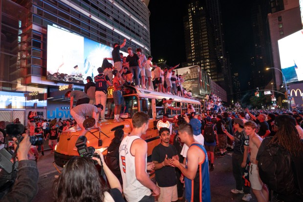 Knicks fans climb on buses on W. 42nd St. in Manhattan after the Knicks defeated the Spurs Saturday, June 13, 2026 in New York City. (Barry Williams/ New York Daily News)