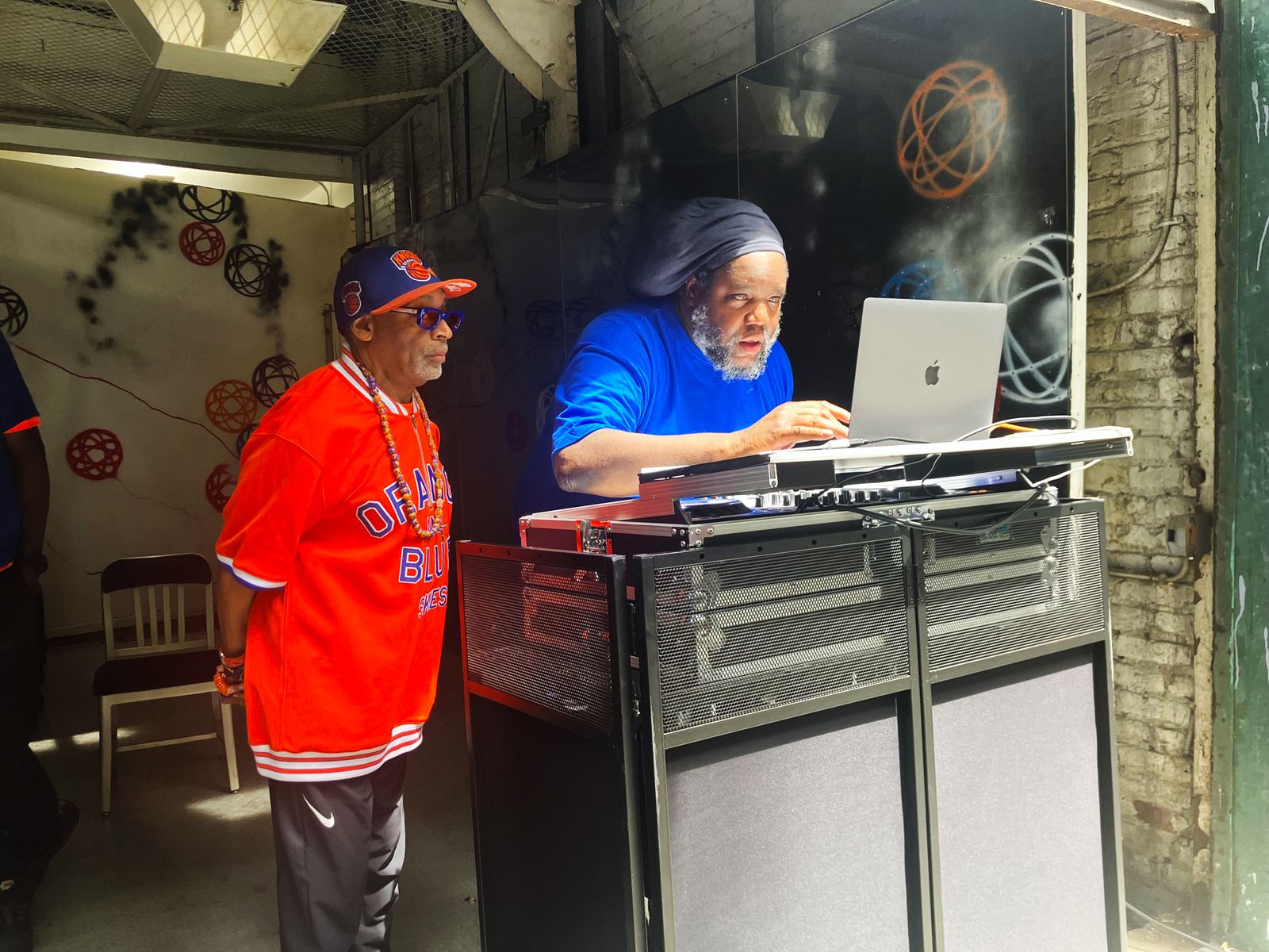 Image may contain The Notorious B.I.G. Spike Lee Furniture Table Desk Adult Person Computer Electronics and Laptop