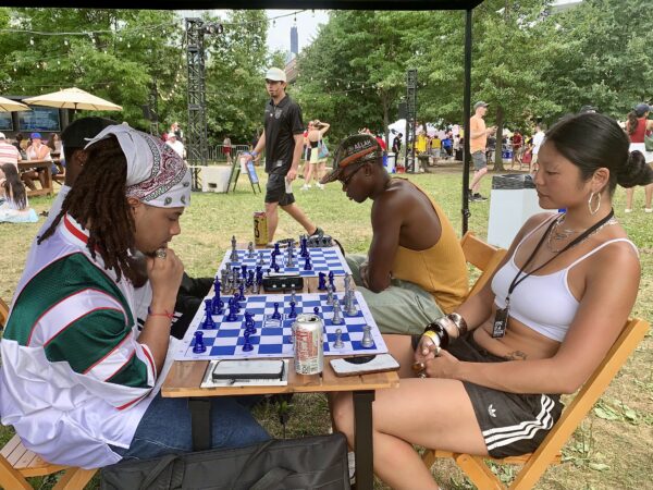 (Far right) Brooklyn activist and model Z, founder of Our Chess NYC, plays a game under the tent at the adidas Brooklyn World Cup Fan Zone. Photo: Mary Frost/Brooklyn Eagle