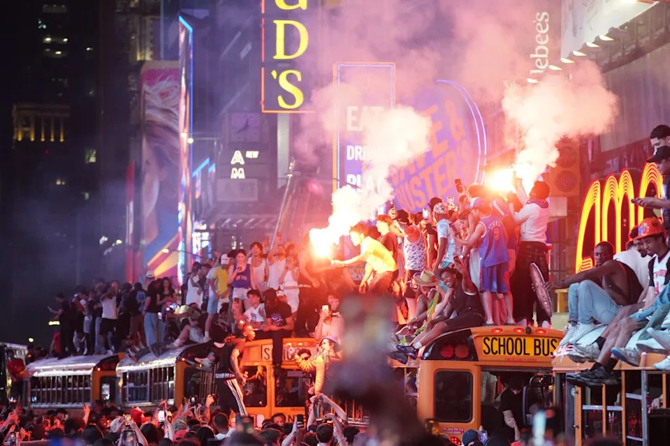 People hold flares as they take over a school bus in Times Square as thousands of Knicks fans celebrate the team’s win. Christopher Sadowski for NY Post