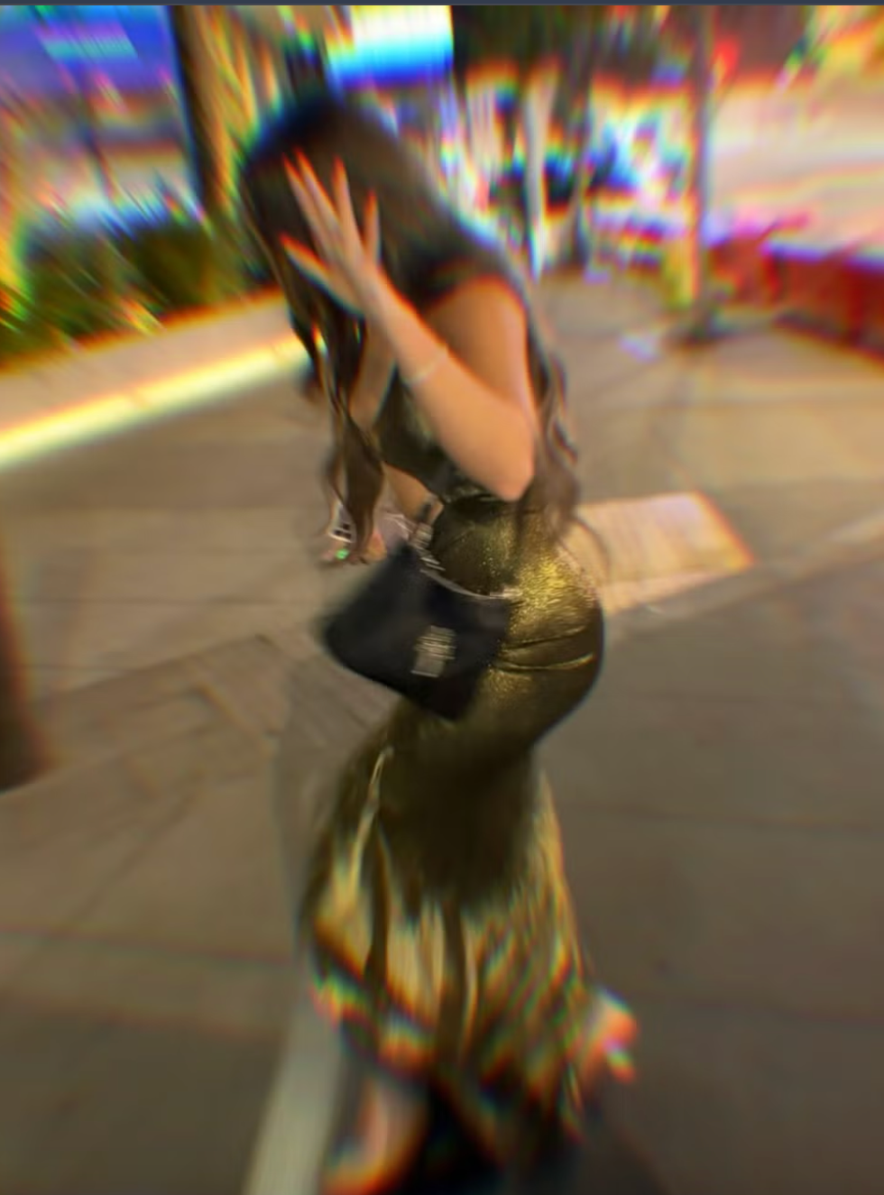 Person in a shimmering gold dress walking on a blurred city street. Person in a shimmering gold dress walking on a blurred city street.