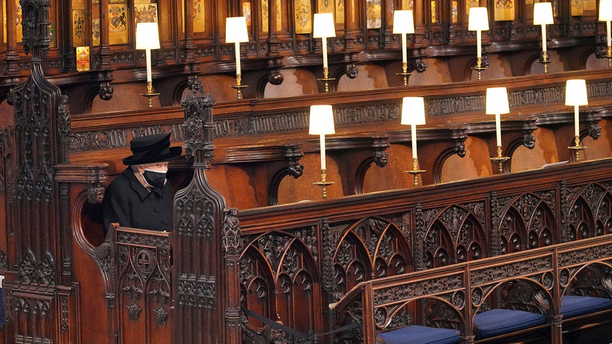 Queen Elizabeth II sitting alone in St. George's Chapel at Windsor Castle