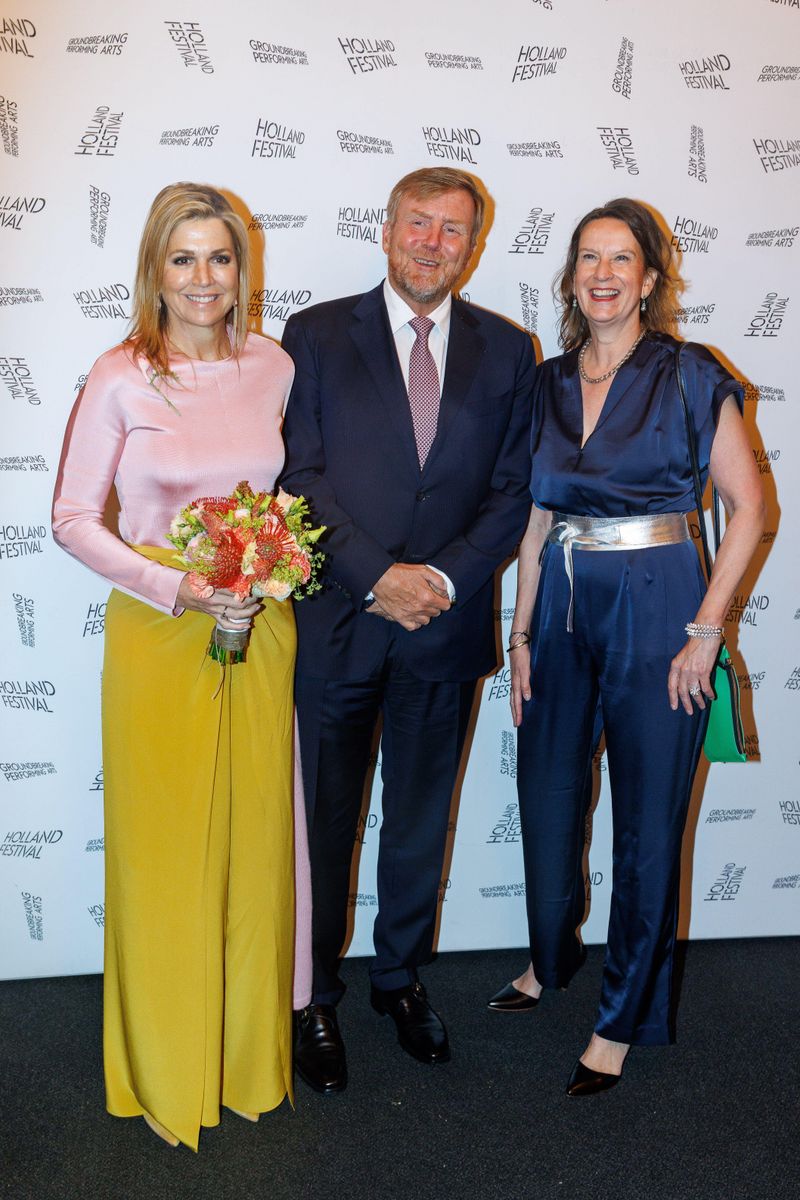 Queen Máxima showcases her sophisticated evening style with a flowing gold skirt, blush pink top, and coordinating woven clutch.