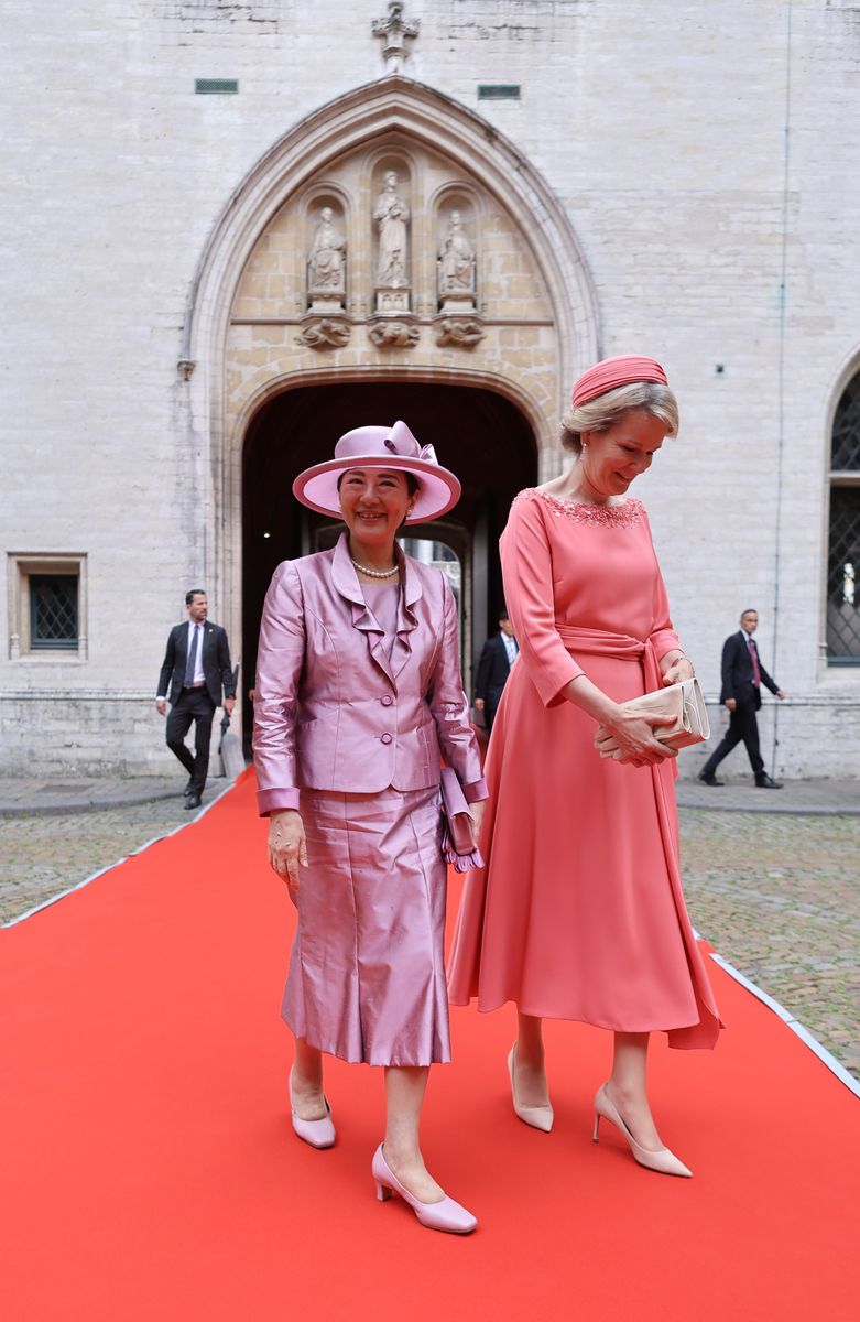 Queen Mathilde paired her coral-pink dress with a coordinating fascinator and understated accessories for the daytime engagements.