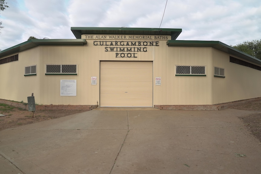 A yellow exterior of a building with the words Gulargambone Pool on the front.