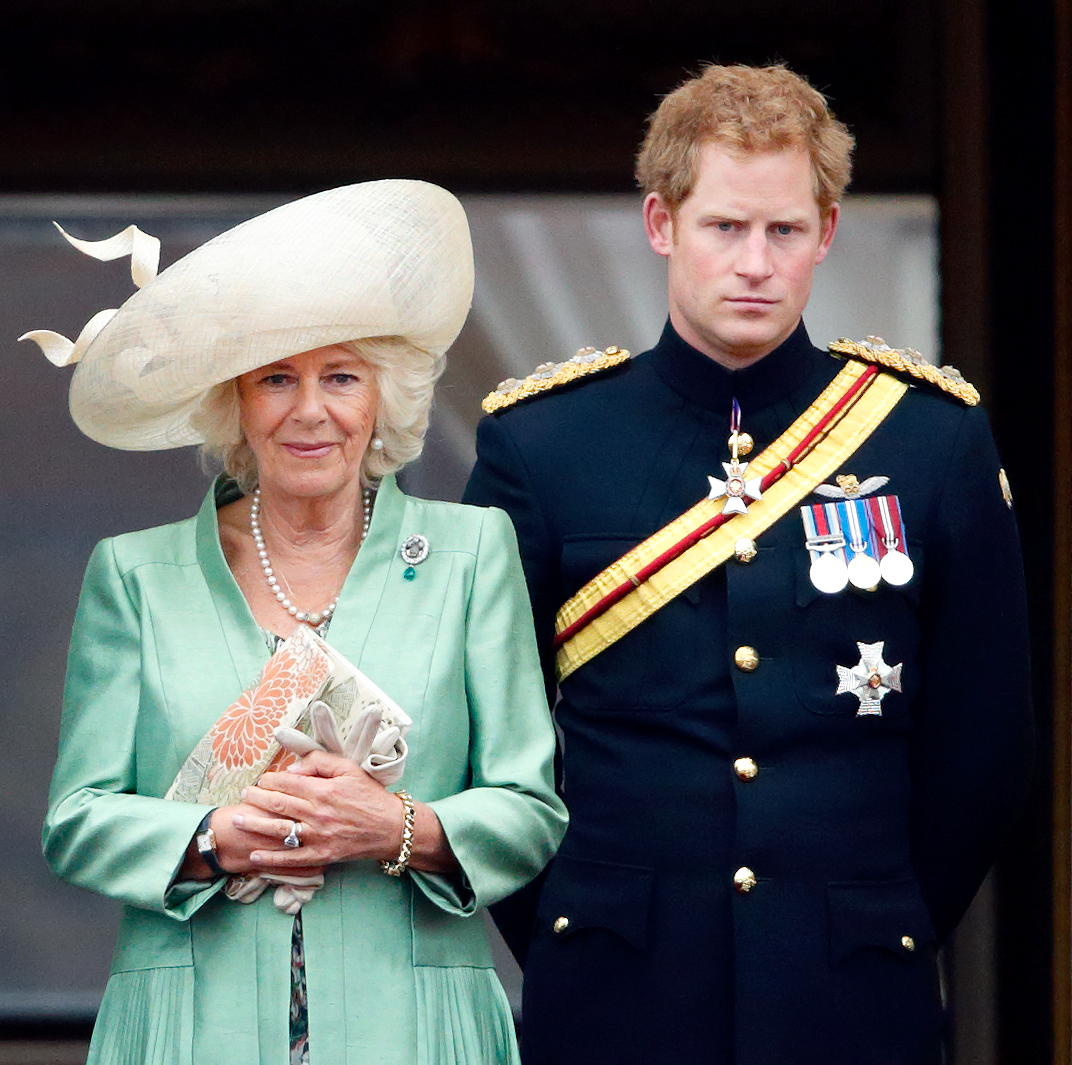 Queen Camilla and Prince Harry stand on the balcony of Buckingham Palace.