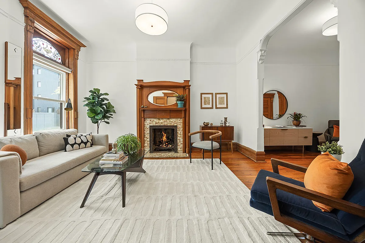 parlor with white walls, mantel, stained glass window