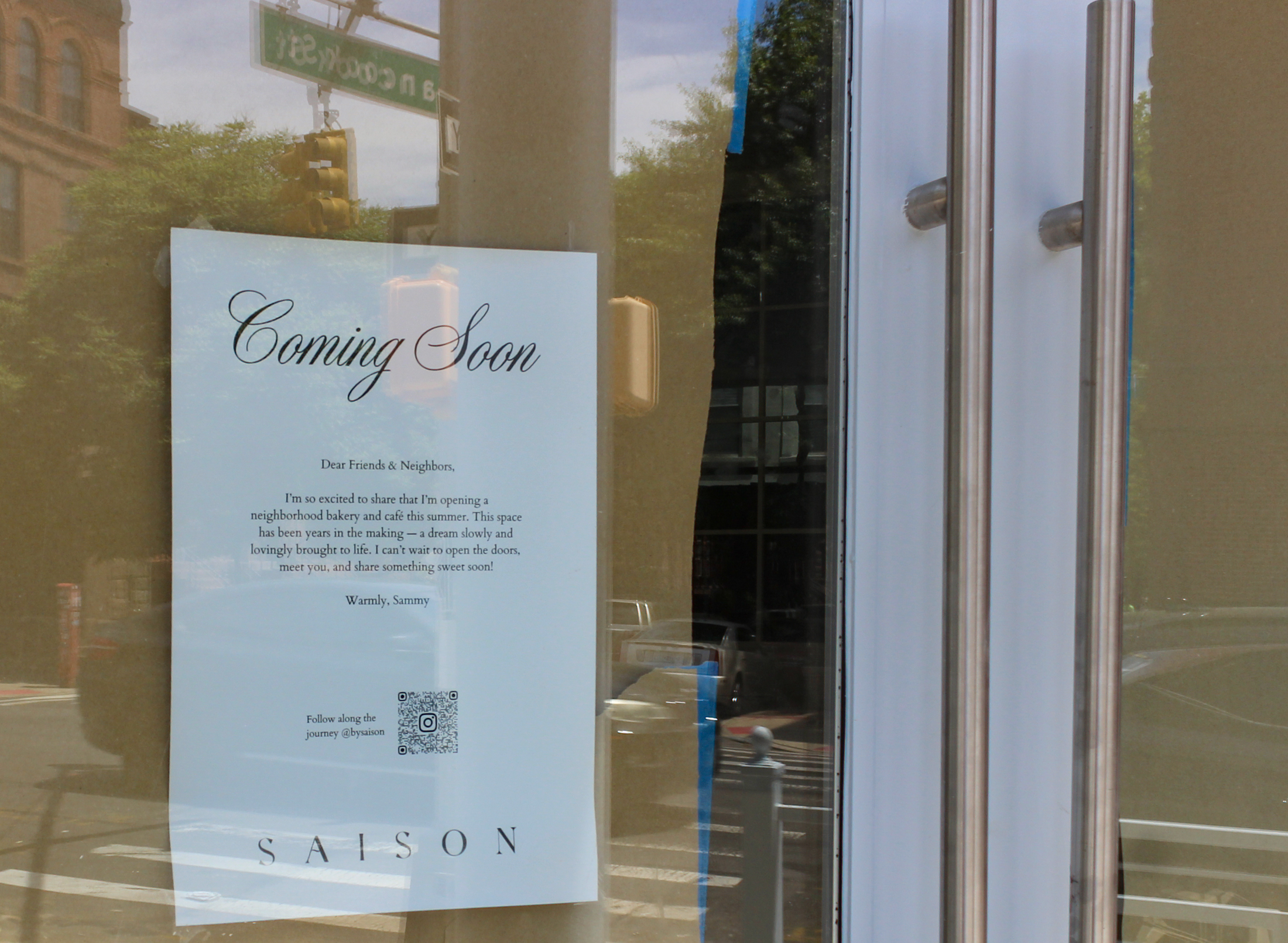 sign in a storefront window announcing Saison as "coming soon"