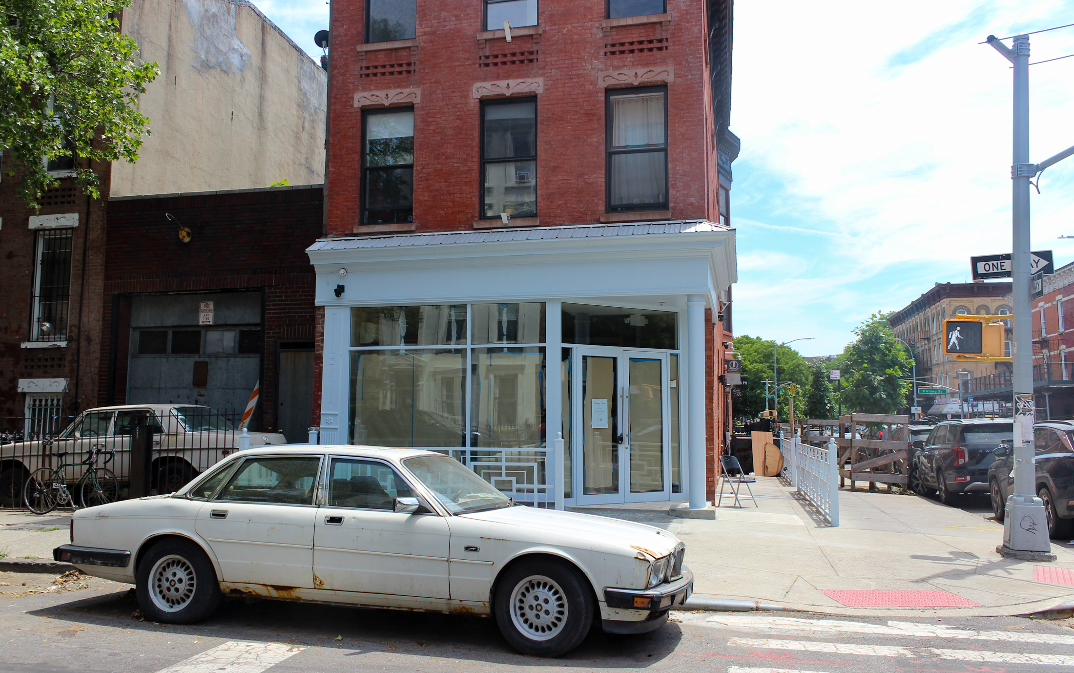 brick building with a white storefront with papered-over windows