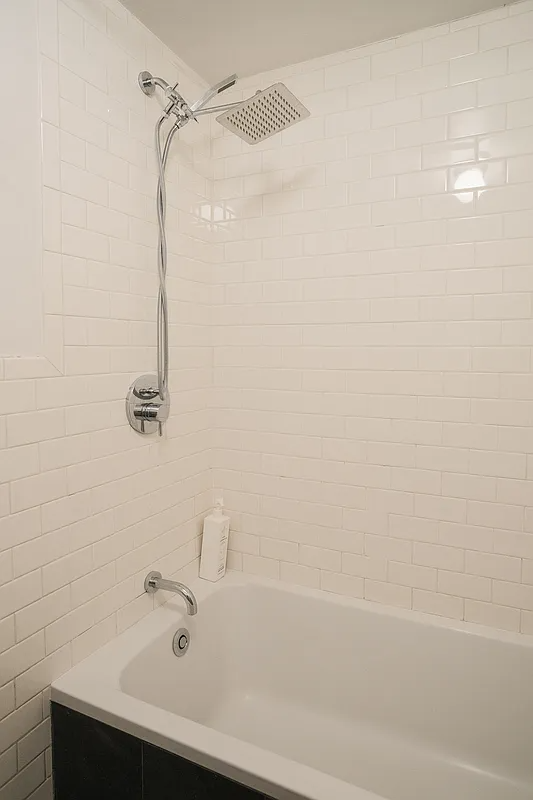 tub with white subway tile on the walls