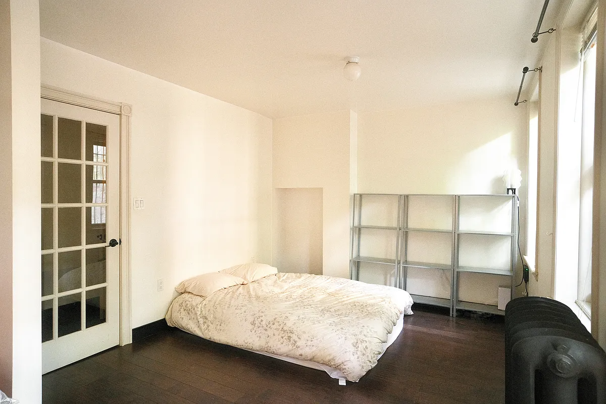 bedroom with glass door, two windows