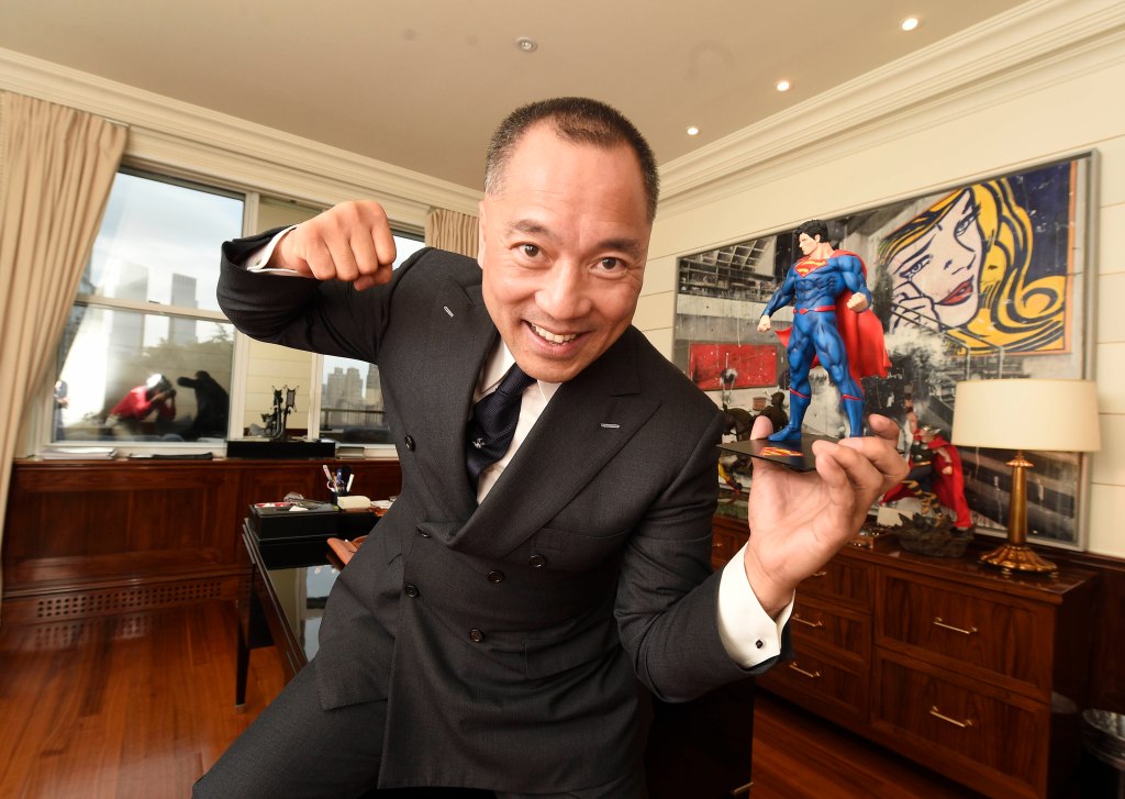 Miles Kwok, a Chinese businessman and activist, posing with a Superman figurine.