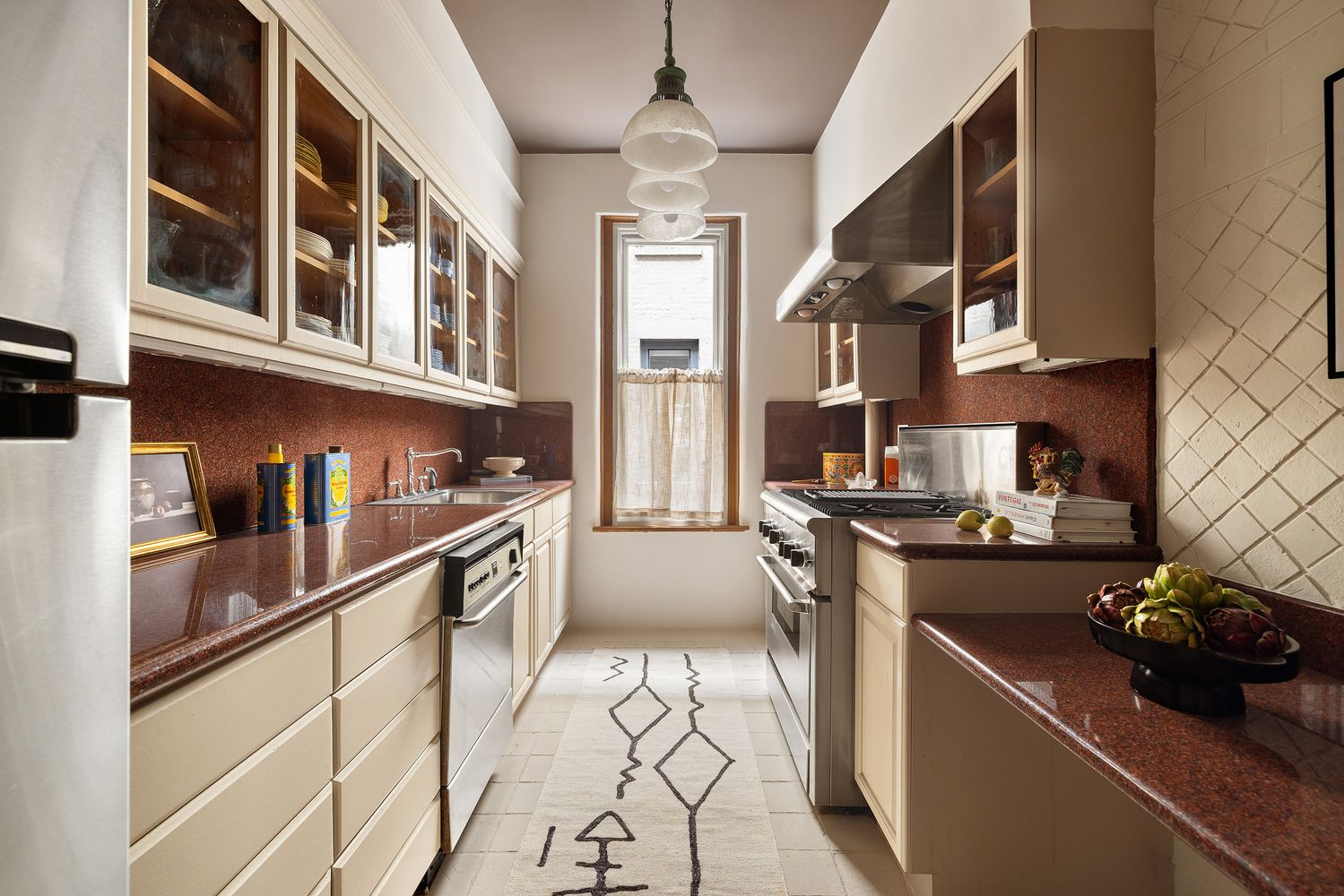 kitchen with beige cabinets and tile and upper cabinets with glass fronts