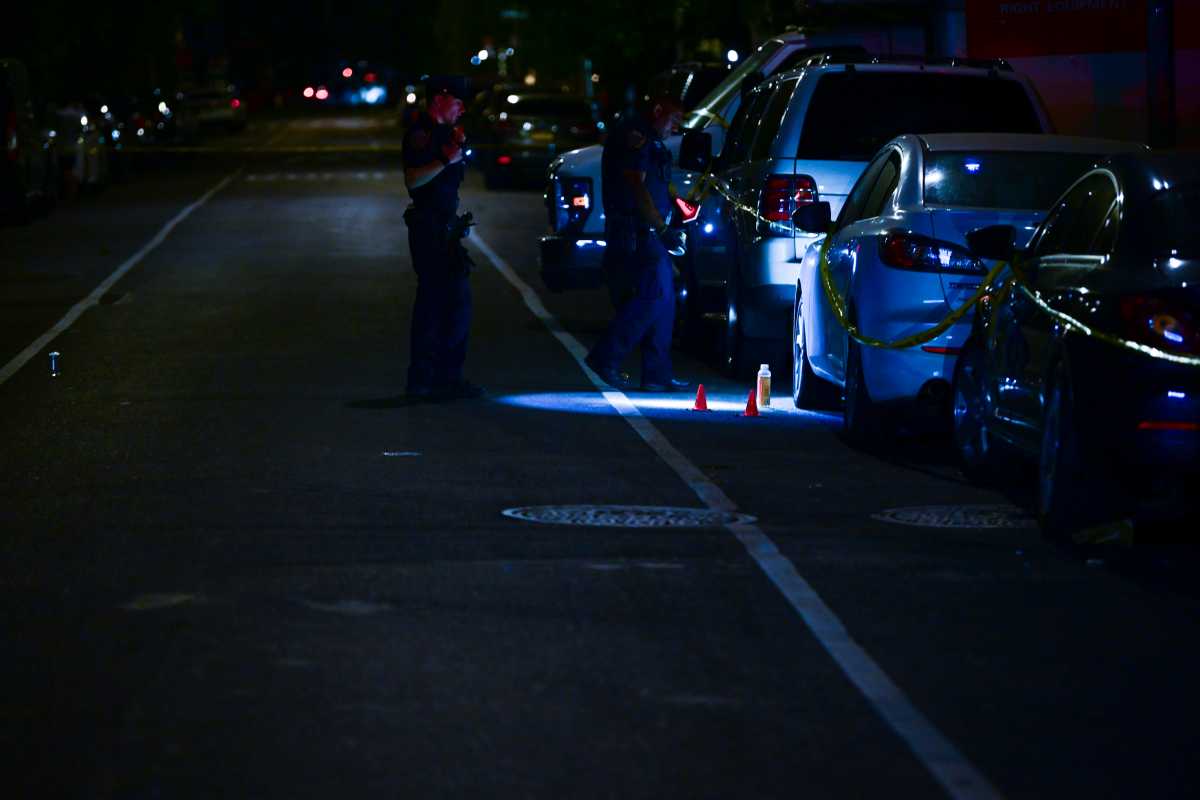 police officer shine light on possible evidence at Brooklyn shooting scene