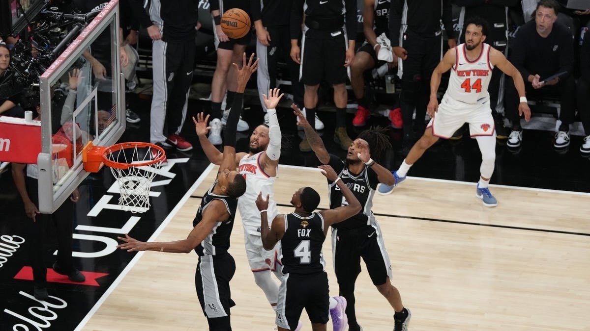New York Knicks guard Jalen Brunson shooting ball past San Antonio Spurs forward Victor Wembanyama during NBA Finals game