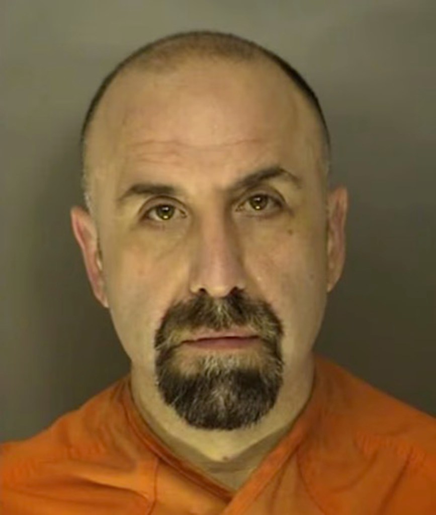 Mugshot of Michael DeBiase, a bald man with a dark goatee, wearing an orange uniform.