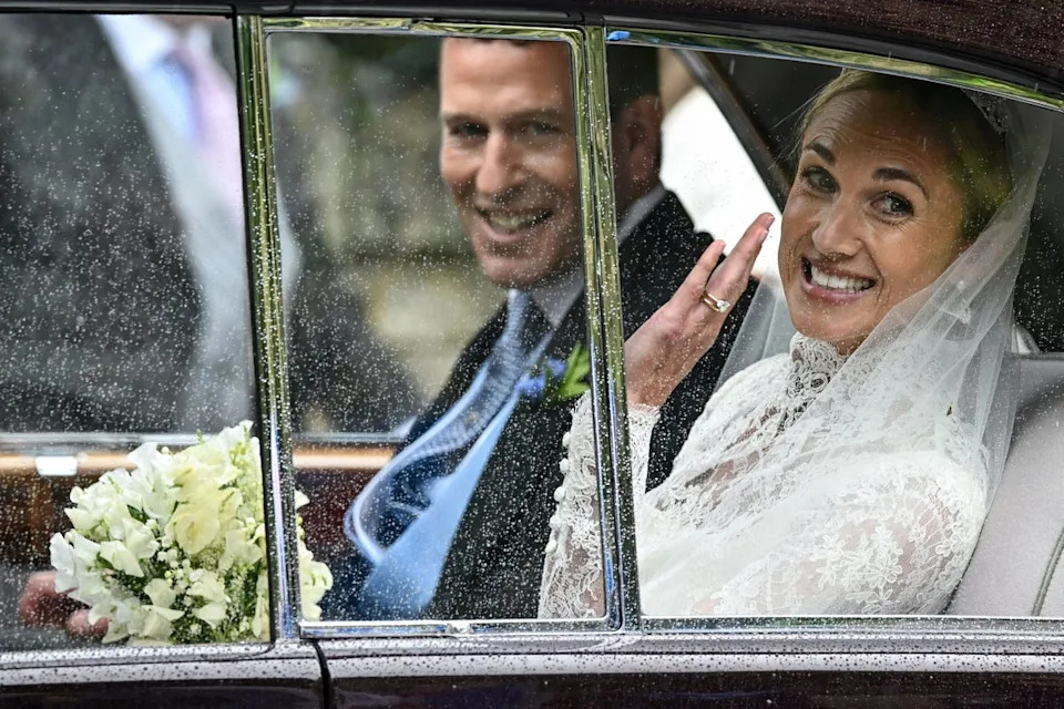 Harriet Sperling waves from a vehicle as she sits with Peter Phillips (Reuters)